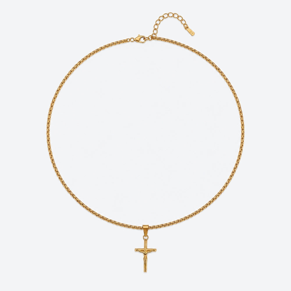 GOLD. A gold box chain necklace with a small crucifix pendant, on a light gray background.