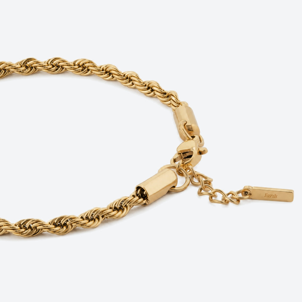 A close-up of a gold rope chain necklace with a lobster clasp, extension chain, and a small rectangular brand tag engraved with 'bora'.