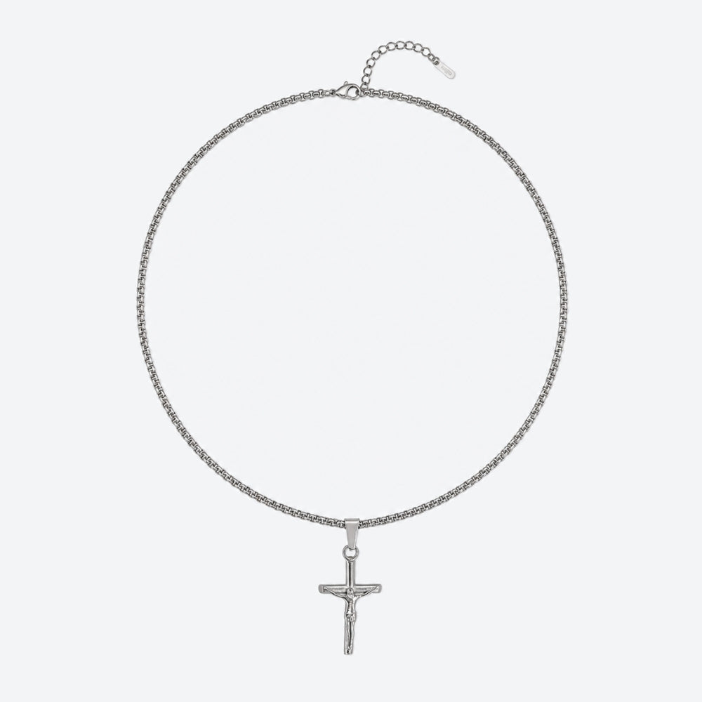SILVER. A silver box chain necklace with a small crucifix pendant, on a light gray background.