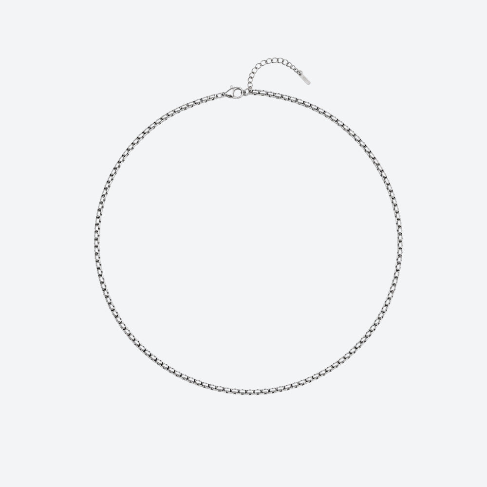 SILVER. A silver box chain necklace with a clasp and extender chain, on a light gray background.