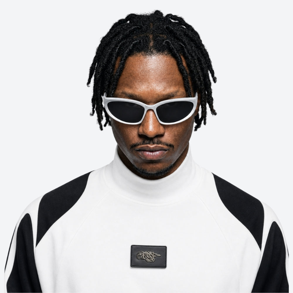 Person wearing a black and VYSER White sunglasses with dark lenses on a white background