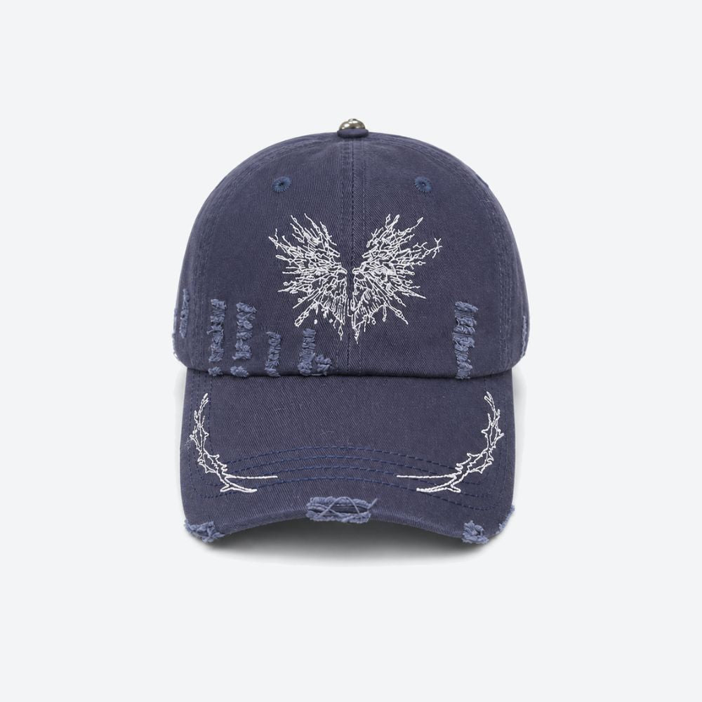 A navy blue distressed baseball cap with a white embroidered moth on the front and thorn branch detailing along the brim, shown from the front