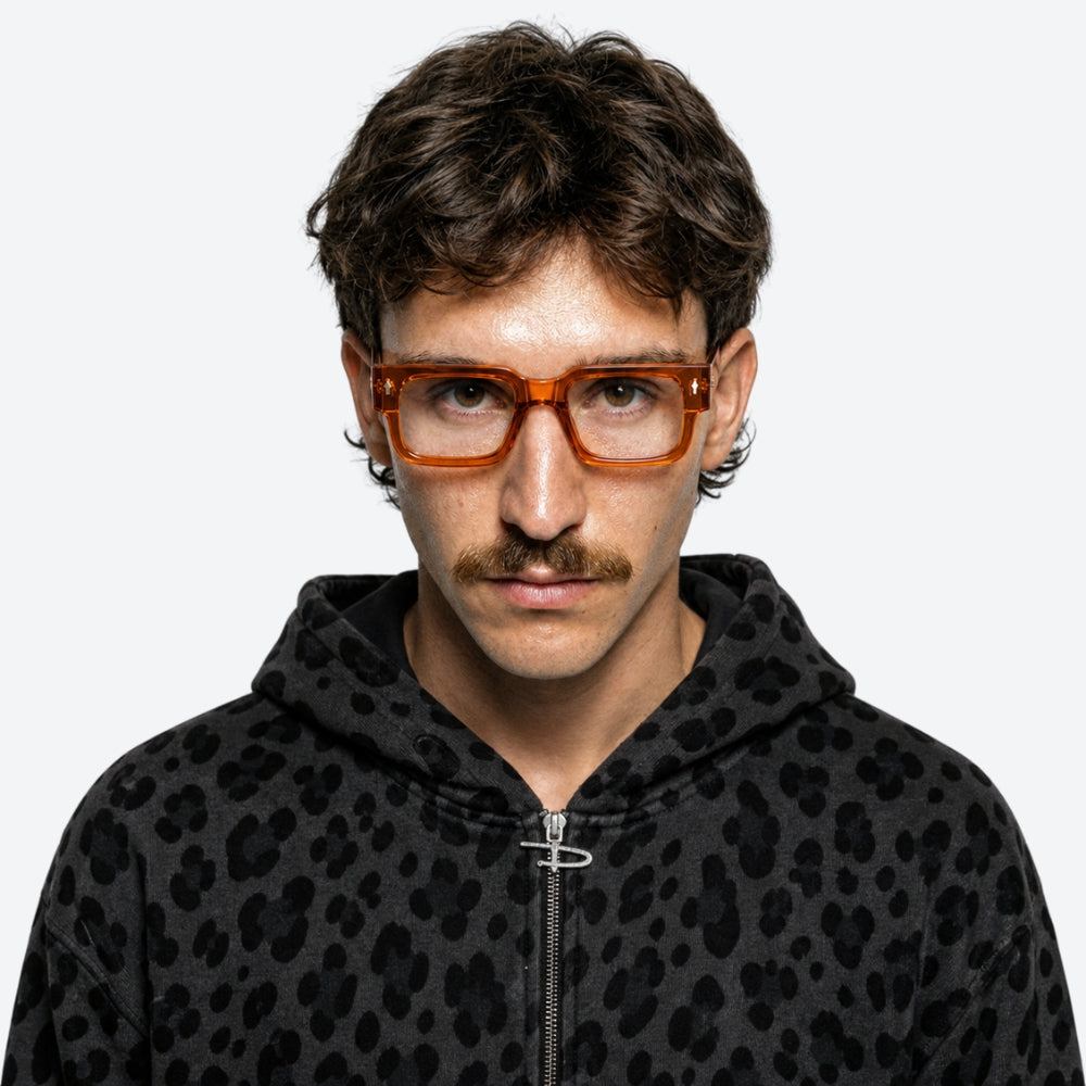Person wearing a black hoodie with a VYSER Orange eyeglasses on a white background