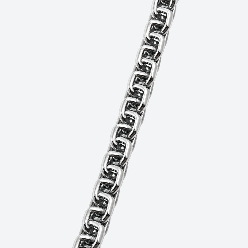 SILVER. A close-up of a polished silver box chain with interlocking links, on a light gray background.