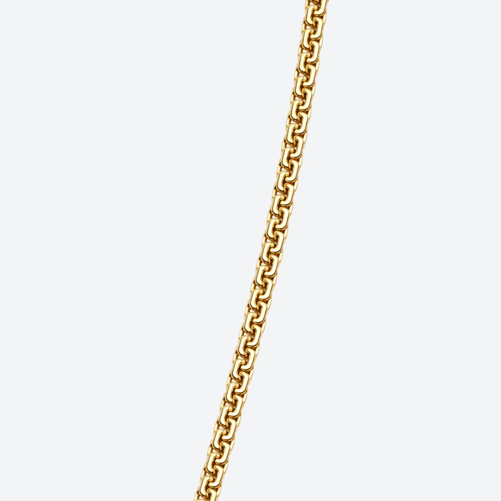 GOLD. A close-up of a gold box chain with interlocking links, shown diagonally on a light gray background.