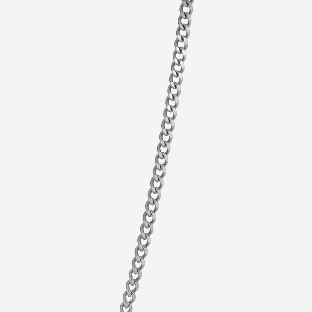 A close-up of a silver-toned metal curb chain running vertically against a plain light gray background.