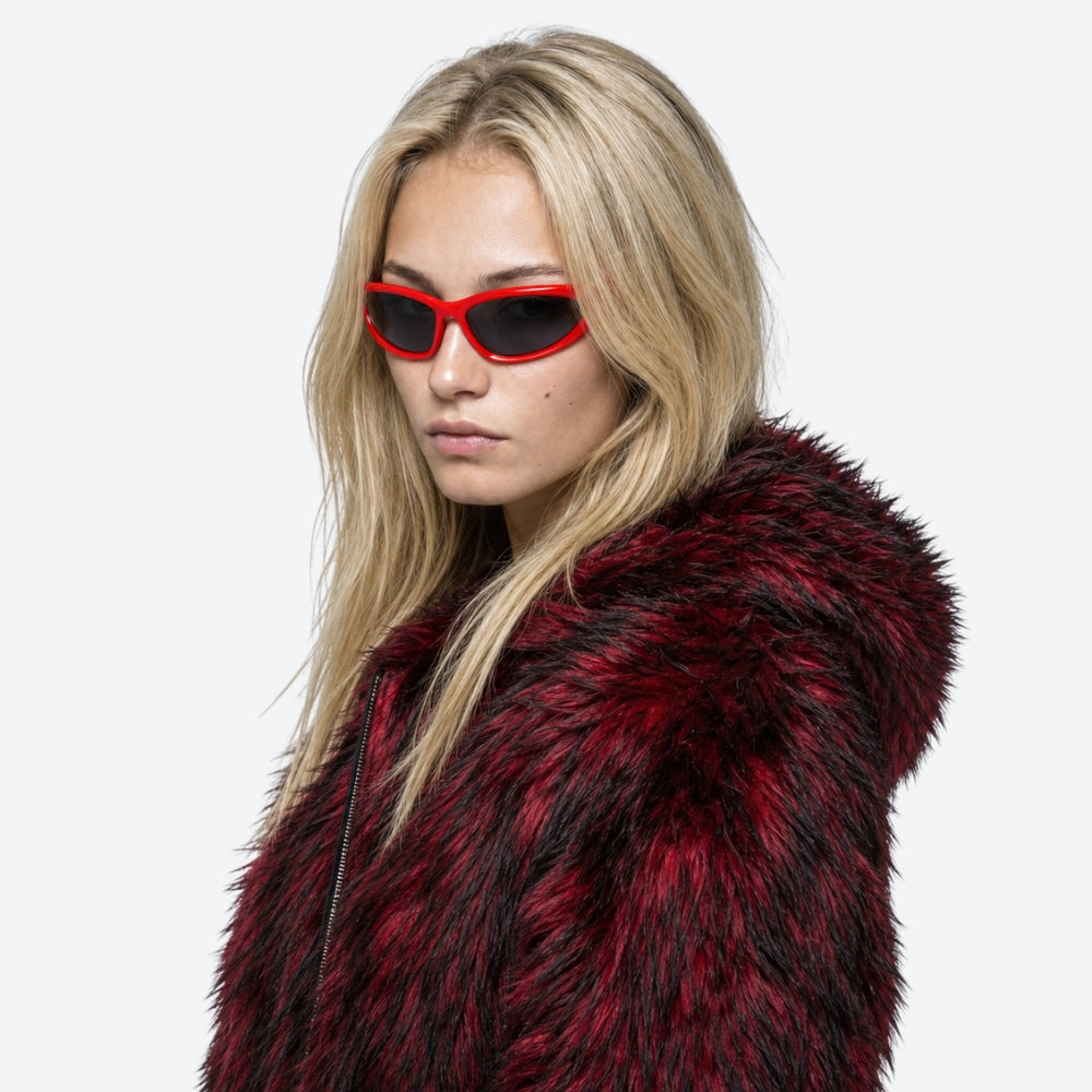 Person wearing a red and black fur coat with VYSER Red sunglasses with dark lenses on a white background
