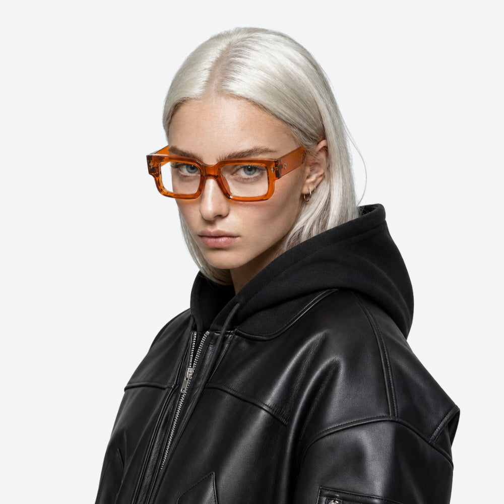 Person wearing a black leather jacket and VYSER Orange eyeglasses on a white background