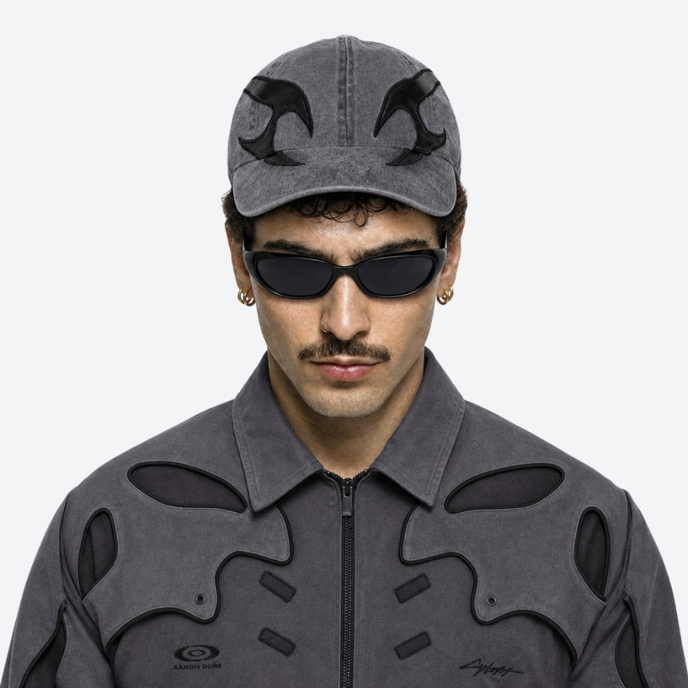 Person wearing a gray cap and jacket with VYSER Black sunglasses with dark lenses on a white background