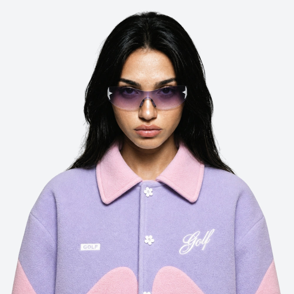 Person wearing a purple and pink outfit with 'Golf' and VYSER Sunglasses with a star design on a white background