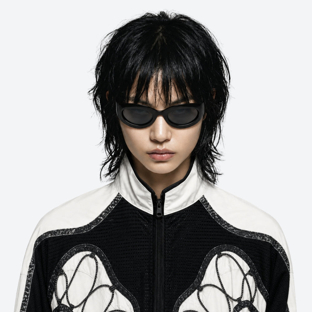 Person wearing a black and white outfit with VYSER Black sunglasses on a white background