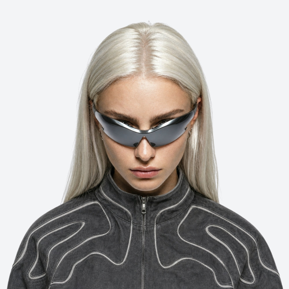 Person wearing futuristic VYSER Silver sunglasses with black frame on a white background
