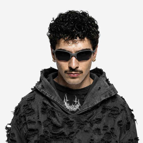 Person wearing a black textured hoodie and VYSER Black sunglasses with dark lenses on a white background