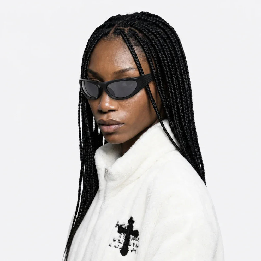Person wearing VYSER Black wrap-around shield sunglasses with dark gray lenses, shown from a three-quarters angle on a light gray background.
