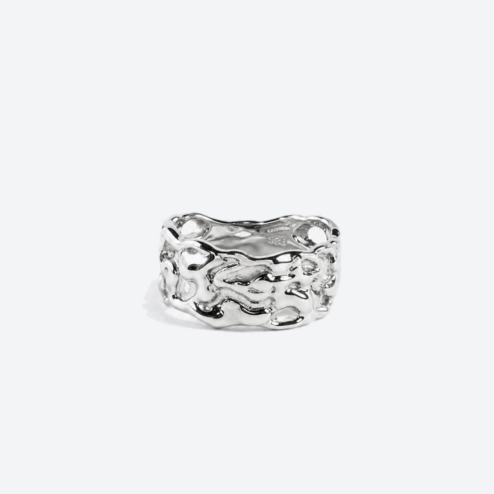 A textured, organic-shaped silver ring with a polished, reflective finish, centered on a light gray background.