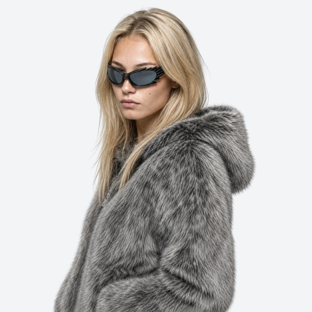Woman wearing a gray fur coat and VYSER Black sunglasses with unique frame design on a white background