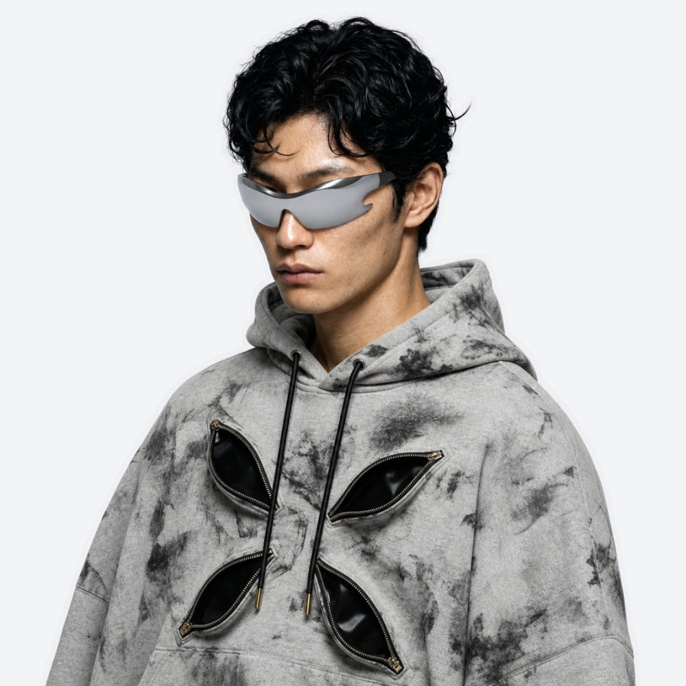 Person wearing a dark gray hoodie and futuristic VYSER Silver sunglasses with black frame on a white background