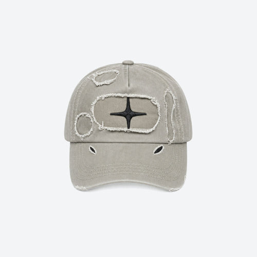 A distressed baseball cap in a light grayish-beige color, featuring a black star emblem surrounded by a frayed white border on the front panel, with additional distressed details on the brim and crown, set against a plain light gray background.