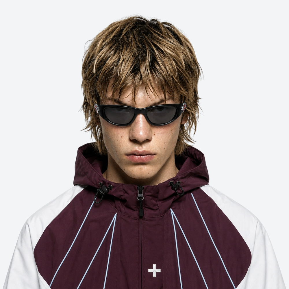 Person wearing a maroon and white jacket with a hood, VYSER Black sunglasses with red and white design on a white background