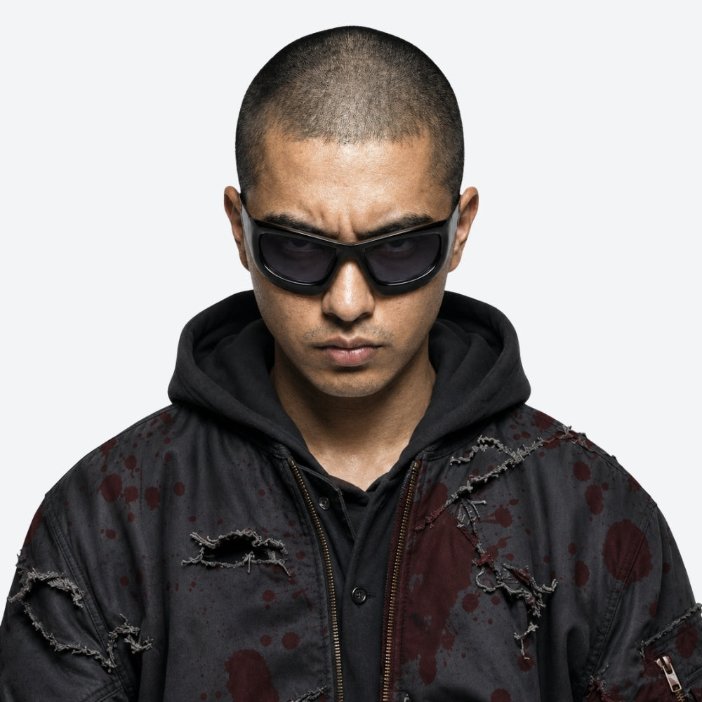 Person wearing a dark hoodie with bloodstain patterns and VYSER Black sunglasses with dark lenses on a white background